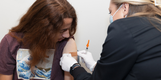 A Lorain County Public Health nurse applies a bandaid after vaccinating a client. 