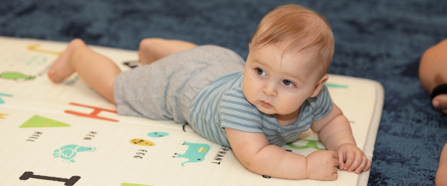 A young child lays on a play mat