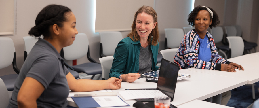 Three women discuss in a meeting 