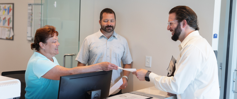 a customer handing a staff member a form of payment 