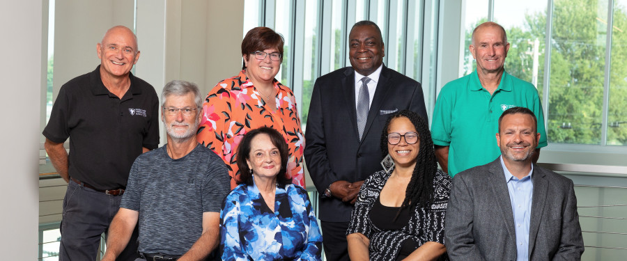 a group photo of 8 board members sitting and standing together 